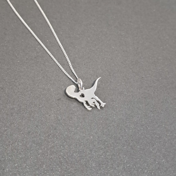 A silver necklace featuring a small dinosaur silhouette pendant, displayed on a textured gray background.