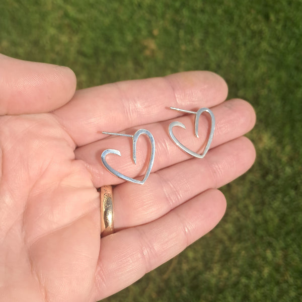Heart hoop earrings shown on hand